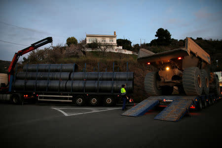 A truck is unloaded from a trailer next to steels tubes, which will be used to protect a deep well, next to the area where Julen, a Spanish two-year-old boy who fell into it, a 25-centimetre (9.8 inch) wide and around 100-metre (328 feet) deep well, four days ago when the family was taking a stroll through a private estate, in Totalan, southern Spain, January 17, 2019. REUTERS/Jon Nazca