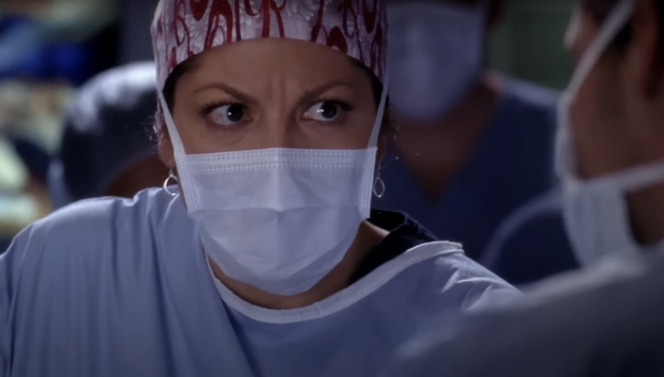 Dr Callie Torres on Grey's Anatomy wearing a surgical mask and looking angry