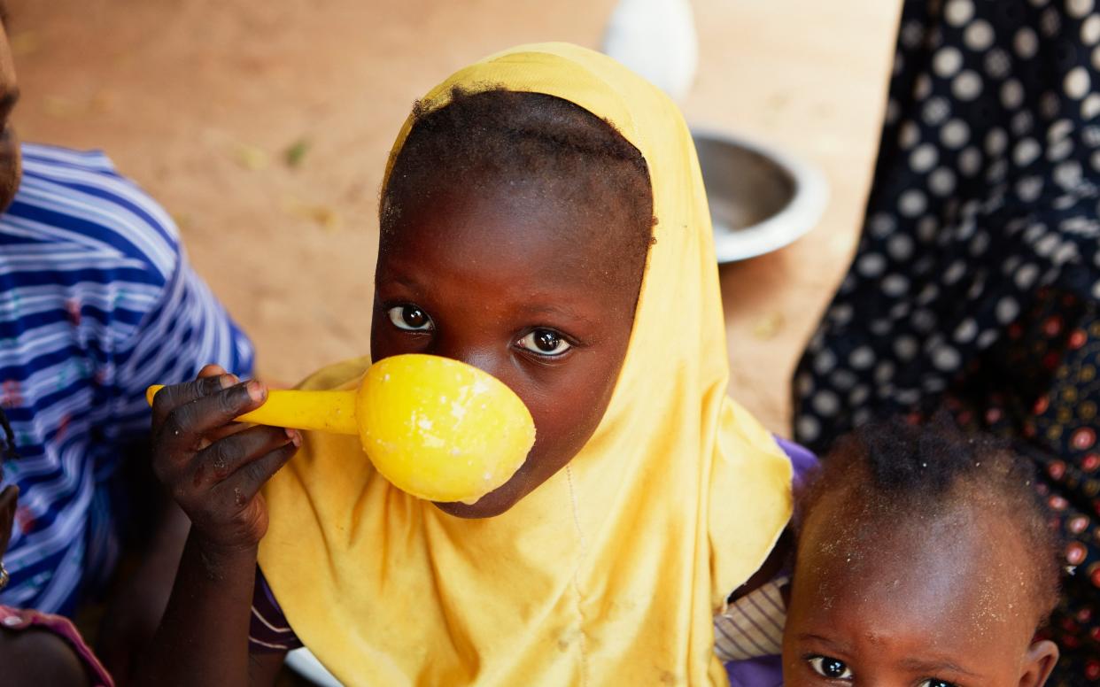 A young girl shares a meal with her siblings in Kietche Village, Niger  - Yuki Sugiura/British Red Cross