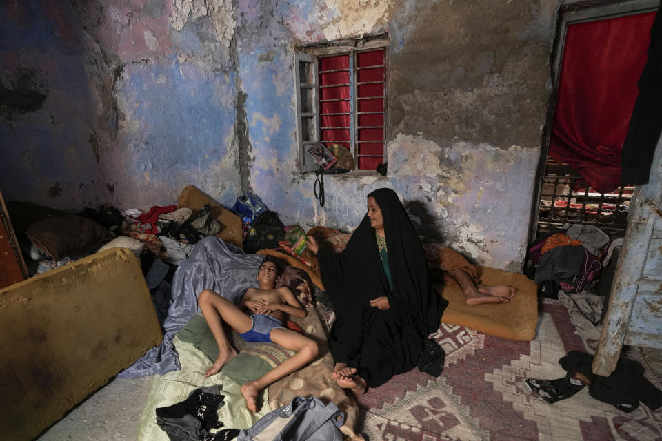 FILE - A Iraqi woman fans her child during a power outage at their home in Baghdad, Iraq, Thursday, July, 6, 2023. A multi-billion dollar agreement signed with France’s TotalEnergies could help resolve Iraq’s longstanding electricity crisis. The $27 billion agreement signed in Baghdad on Monday, July 10, 2023, after years of negotiation marks the largest foreign investment in Iraq’s history. (AP Photo/Hadi Mizban, File)