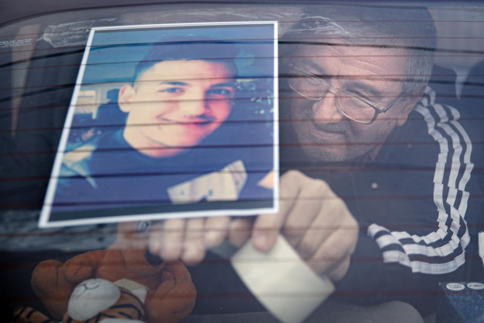 Stelian Danciu, the uncle of Vili Viorel Paun, a 23 year-old man killed in the Hanau shootings, places his photo on the back window of the taxi he drives, in Singureni, southern Romania, Friday, Feb. 21, 2020. A 43-year-old German man shot dead nine people of immigrant backgrounds in the Frankfurt suburb of Hanau on Wednesday night before killing his mother and himself. He left a number of rambling texts and videos espousing racist views. (AP Photo/Vadim Ghirda)