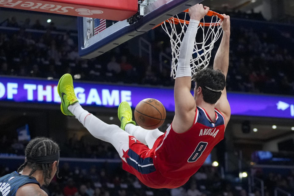 Washington Wizards forward Deni Avdija hangs from the rim after a dunk during the first half of an NBA basketball game against the Orlando Magic, Wednesday, March 6, 2024, in Washington. (AP Photo/Alex Brandon)