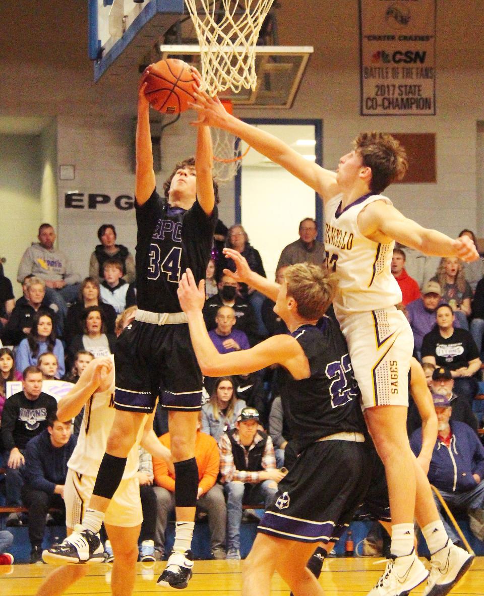 Micah Meiss of El Paso-Gridley grabs a rebounds as teammate Jake Funk tries to block out Joey Sprinkle of Monticello Friday night.