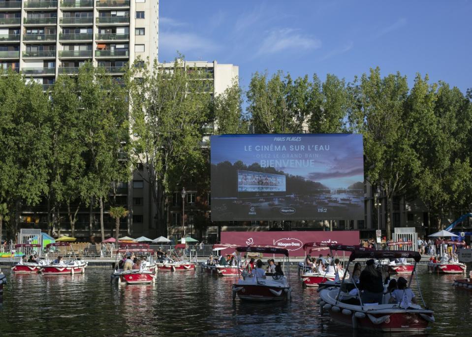 People on small boats prepare for "Le Cinema Sur L'Eau," or Cinema on the Water, in Paris