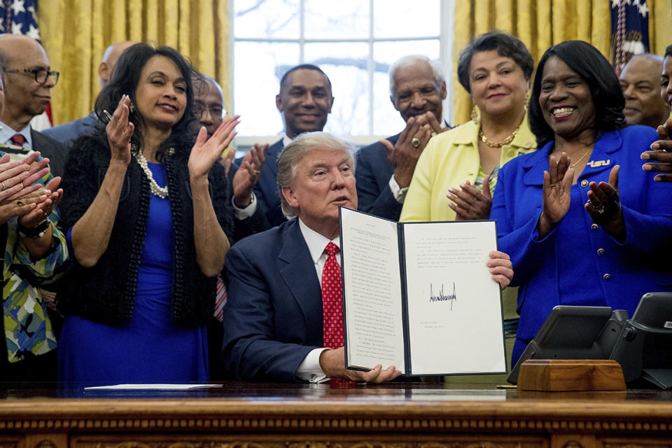 President Donald Trump holds up the Historically Black Colleges and Universities HBCU Executive Order after signing it, Tuesday, Feb. 28, 2017, in the Oval Office in the White House in Washington. (AP Photo/Andrew Harnik)