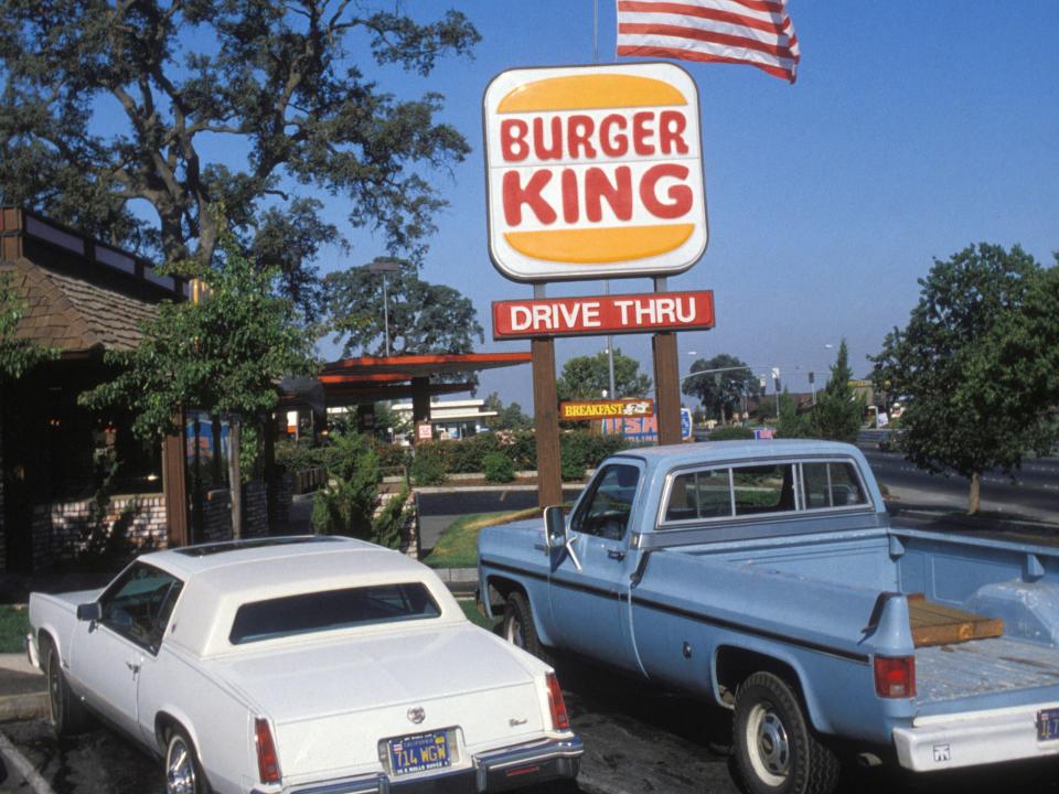 A Burger King drive-thru sign and cars in 1982