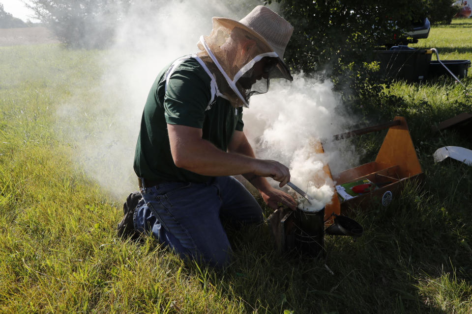 In July 11, 2019 photo, Adam Ingrao, an agricultural entomologist and military veteran who runs the Heroes to Hives program, prepares a bee smoker at the Henry Ford farm in Superior Township, Mich. Ingrao, a fourth-generation soldier, runs Heroes to Hives through Michigan State University Extension. “You’re not thinking about what happened in Afghanistan or Iraq. You’re thinking about what’s happening right here, right now.” (AP Photo/Carlos Osorio)