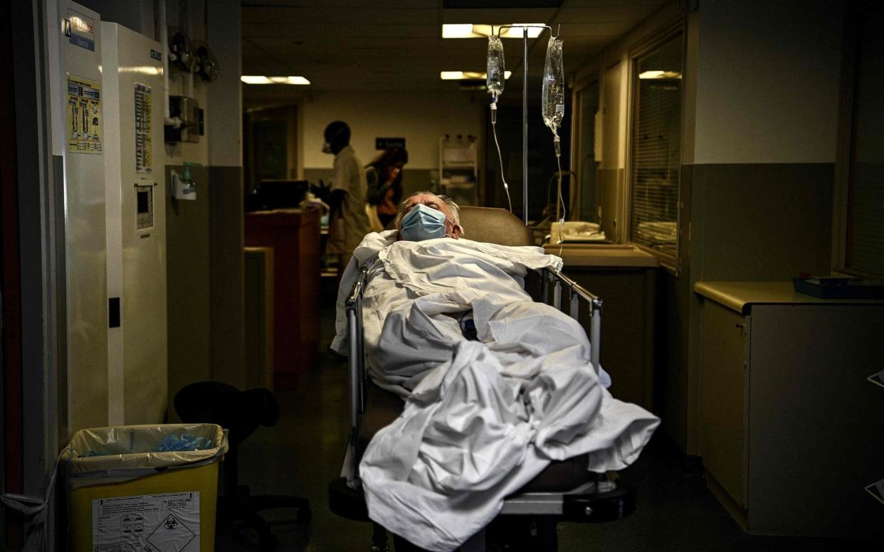 A Covid-19 patient leaves on a stretcher the intensive care unit of the Hopital Prive hospital in southern Paris  - CHRISTOPHE ARCHAMBAULT/AFP via Getty Images