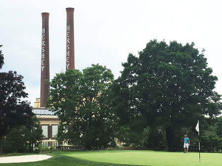 A golfer walks across the Hershey Country Club that overlooks an old Hershey Co. chocolate factory in Hershey, Pennsylvania, U.S. on July 2, 2016. Picture taken July 2, 2016. REUTERS/Koh Gui Qing