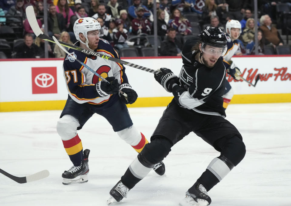 Los Angeles Kings right wing Adrian Kempe, front, gets his stick tangled with that of Colorado Avalanche left wing J.T. Compher during the second period of an NHL hockey game Thursday, Dec. 29, 2022, in Denver. (AP Photo/David Zalubowski)