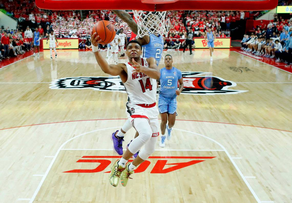 N.C. State’s Casey Morsell (14) heads to the basket past North Carolina’s Caleb Love (2) during N.C. State’s 77-69 victory over UNC at PNC Arena in Raleigh, N.C., Sunday, Feb. 19, 2023.
