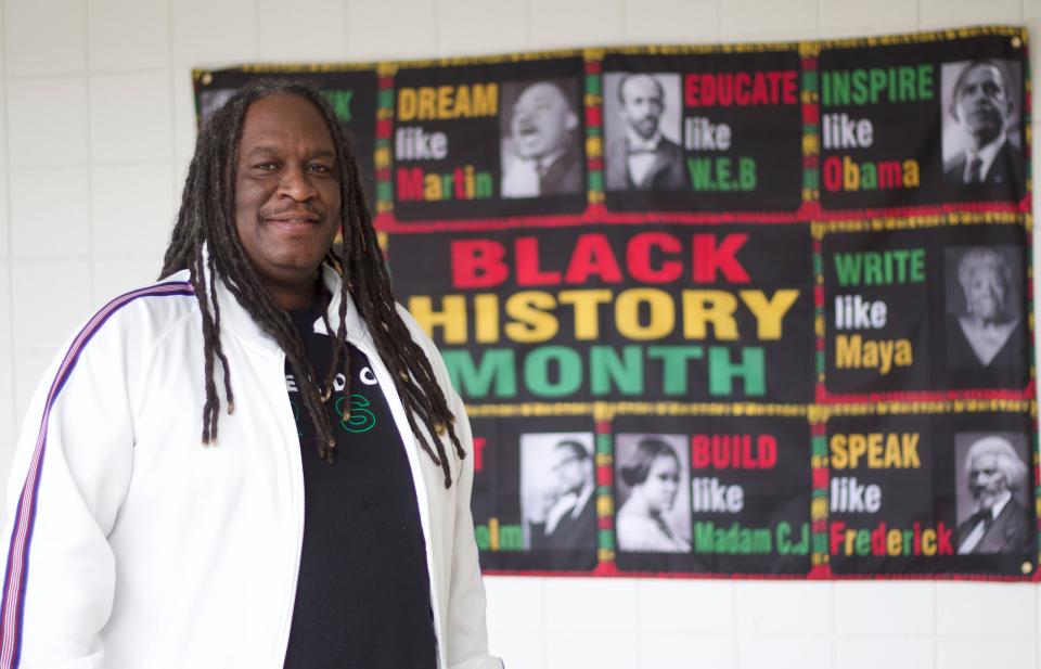 Kevin Summerfield, social studies teacher at Sheldon High School, poses in front of a Black History Month banner that is displayed at the school for the month of February on Monday, Feb. 19, 2024.