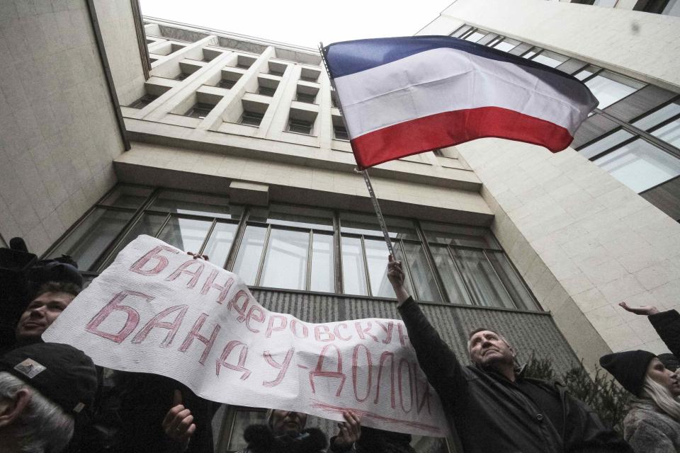 A man holds a flag of Crimea during a rally organized mainly by ethnic Russians in Simferopol