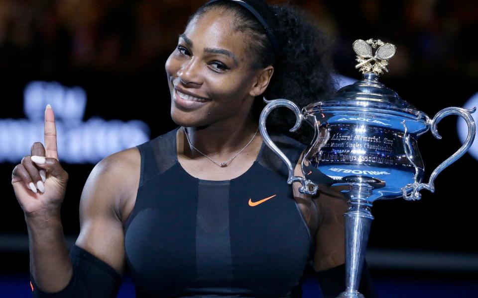 Serena Williams holds up a finger and her trophy after defeating her sister, Venus, in the women's singles final at the Australian Open tennis championships - Credit: AP