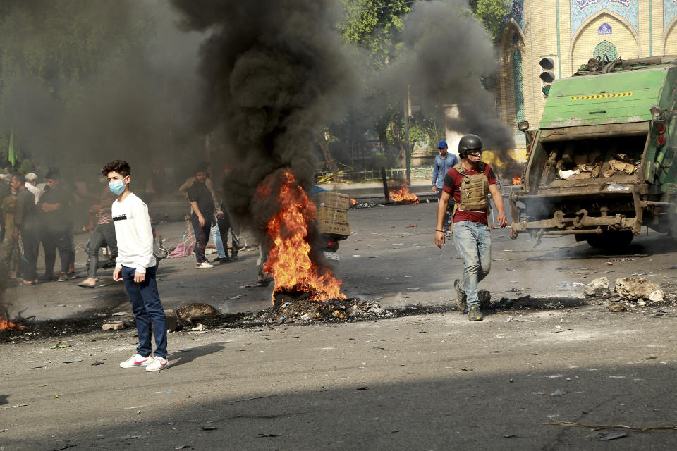 Fires set by protesters close roads during ongoing anti-government protests in Baghdad, Iraq, Sunday, Nov. 3, 2019. Iraqi protesters have begun blocking roads in Baghdad to raise pressure on the government to resign. (AP Photo/Hadi Mizban)