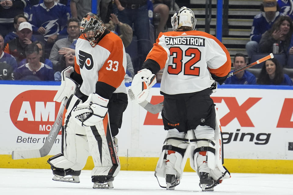 Philadelphia Flyers goaltender Samuel Ersson (33) skates off after being replaced by goaltender Felix Sandstrom (32) during the first period of an NHL hockey game against the Tampa Bay Lightning Saturday, March 9, 2024, in Tampa, Fla. Ersson gave up four goals in the period. (AP Photo/Chris O'Meara)