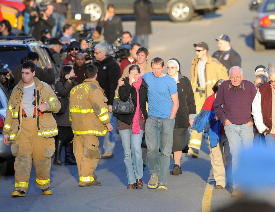 A couple is seen walking amid an array of firefighters and others.