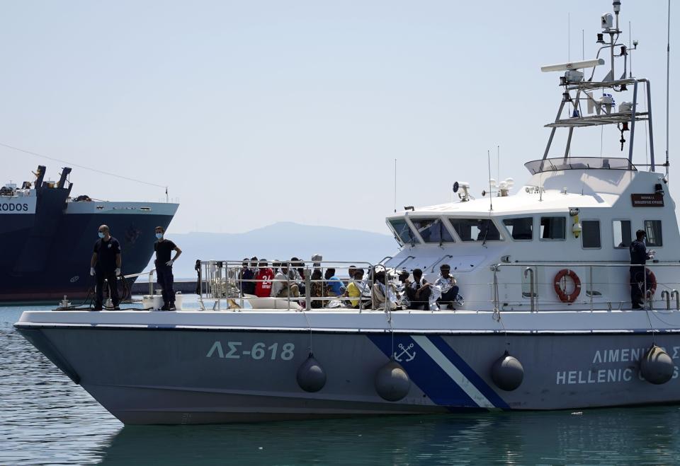Migrants sit on the deck of a coast guard vessel upon their arrival at Mytilene port, on the northeastern Aegean Sea island of Lesbos, Greece, Wednesday, June 22, 2022. A coast guard official said 30 adult Eritreans ‒ 25 men and five women ‒ were spotted during a patrol near Lesbos. (AP Photo/Panagiotis Balaskas)