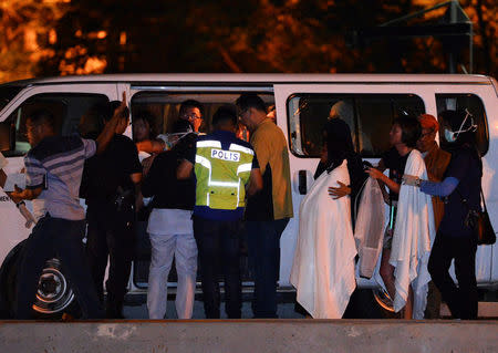 Police coast guards escort Chinese tourists rescued after their boat sank off the coast of Borneo, at a port in Kota Kinabalu, Malaysia early January 30, 2017. REUTERS/Stringer