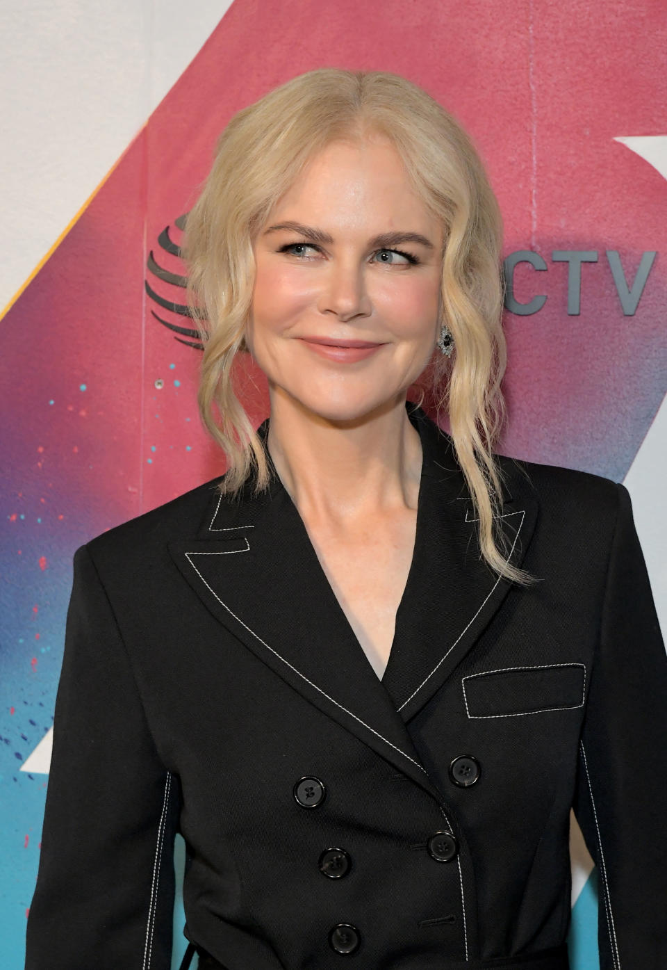 Woman posing, wearing a double-breasted blazer, with a slight smile