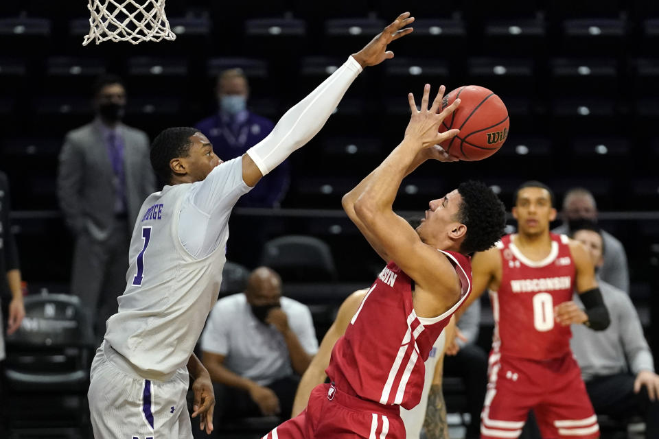 Wisconsin guard Jonathan Davis, right, shoots against Northwestern guard Chase Audige during the first half of an NCAA college basketball game in Evanston, Ill., Saturday, Feb. 21, 2021. (AP Photo/Nam Y. Huh)