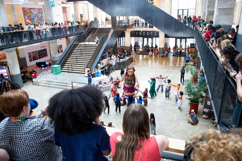 Little Amal, a 12-foot-tall puppet of a ten-year-old Syrian refugee child, dances with the dance team of Crosstown High at Crosstown Concourse in Memphis, Tenn., on Wednesday, October 4, 2023. The students and staff of Crosstown High planned the event and invited Little Amal.