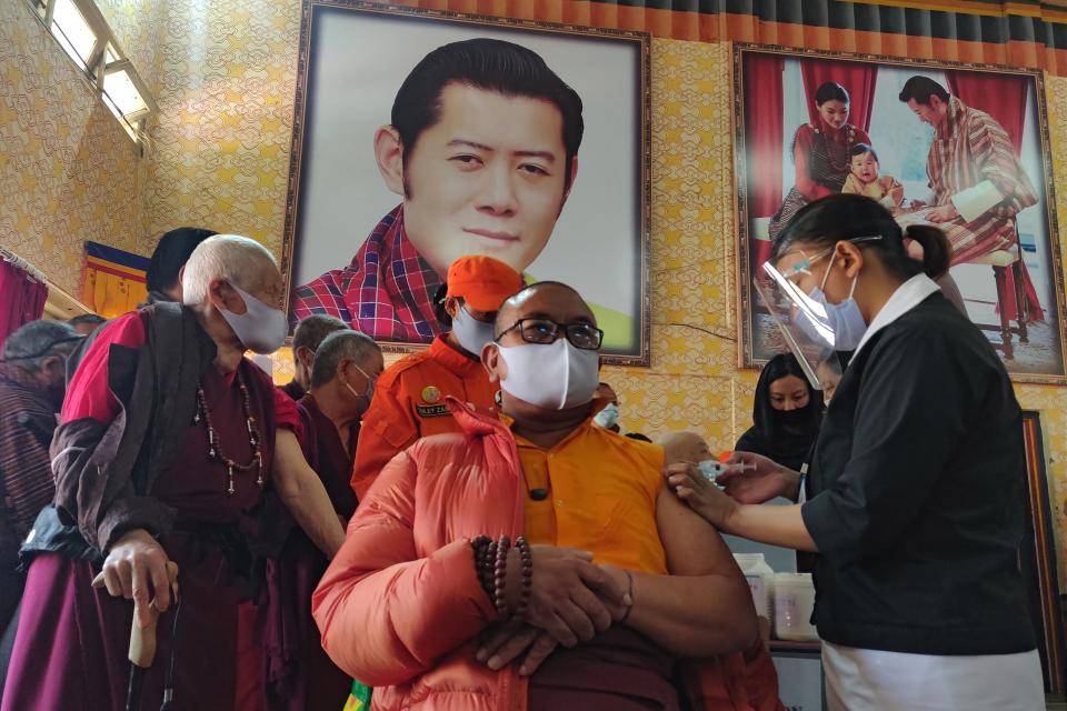 A health worker administers a coronavirus vaccine to a Buddhist monk during the first day of vaccination in Bhutan on March 27. Source: Getty