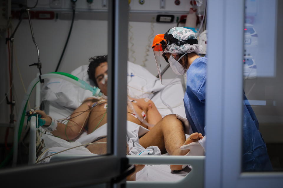 Doctors and nurses tend to a young man in ICU in Argentina. Source: EPA/AAP