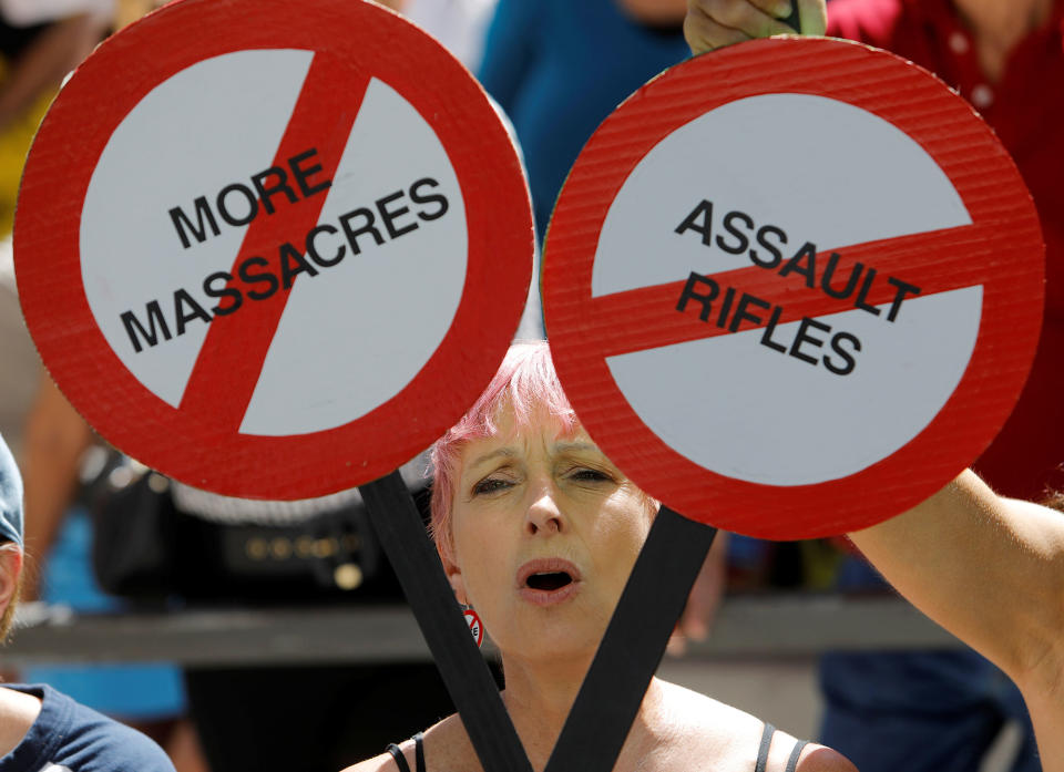 <p>A protester holds a sign calling for a reform of gun laws in front of a flag flying at half mast in honor of the victims of the shooting at Marjory Stoneman Douglas High School, at a rally in Fort Lauderdale, Fla., Feb. 17, 2018. (Photo: Jonathan Drake/Reuters) </p>