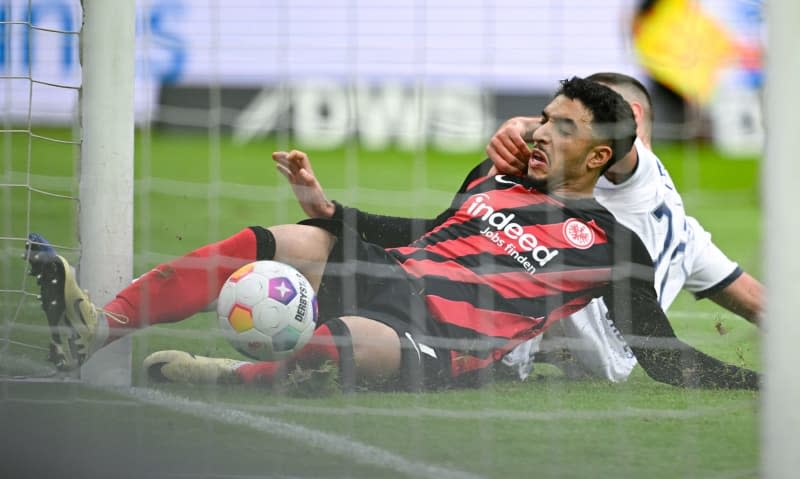 Eintracht Frankfurt's Omar Marmoush (L) scores his side's first goal of the game after battling for the ball against Bochum's Ivan Ordets during the German Bundesliga soccer match between Eintracht Frankfurt and VfL Bochum at Deutsche Bank Park. Arne Dedert/dpa