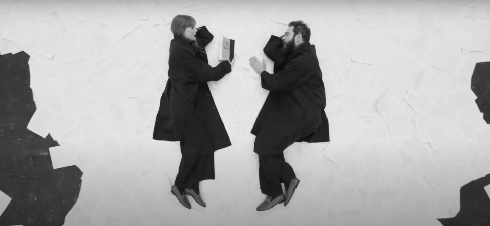 Taylor Swift and Post Malone lay on a pile of pages wearing matching gucci loafers