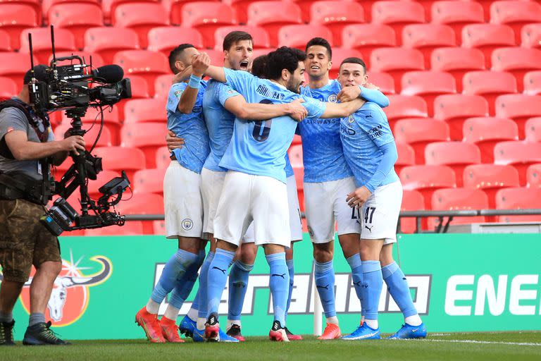 Londres, Inglaterra - 25 de abril: Aymeric Laporte del Manchester City (oculto) celebra con Ilkay Gundogan, Ferran Torres y Phil Foden después de anotar el primer gol de su equipo durante la final de la Copa Carabao entre Manchester City y Tottenham Hotspur en el estadio de Wembley el 25 de abril de 2021 en Londres, Inglaterra. 8,000 fanáticos verán el juego en Wembley, la mayor cantidad en un evento deportivo al aire libre en el Reino Unido desde que comenzó la pandemia de coronavirus en marzo de 2020. Cada equipo recibió una asignación de 2,000 con las entradas restantes divididas entre los residentes locales y el NHS. personal. (Foto de Tom Flathers / Manchester City FC a través de Getty Images)