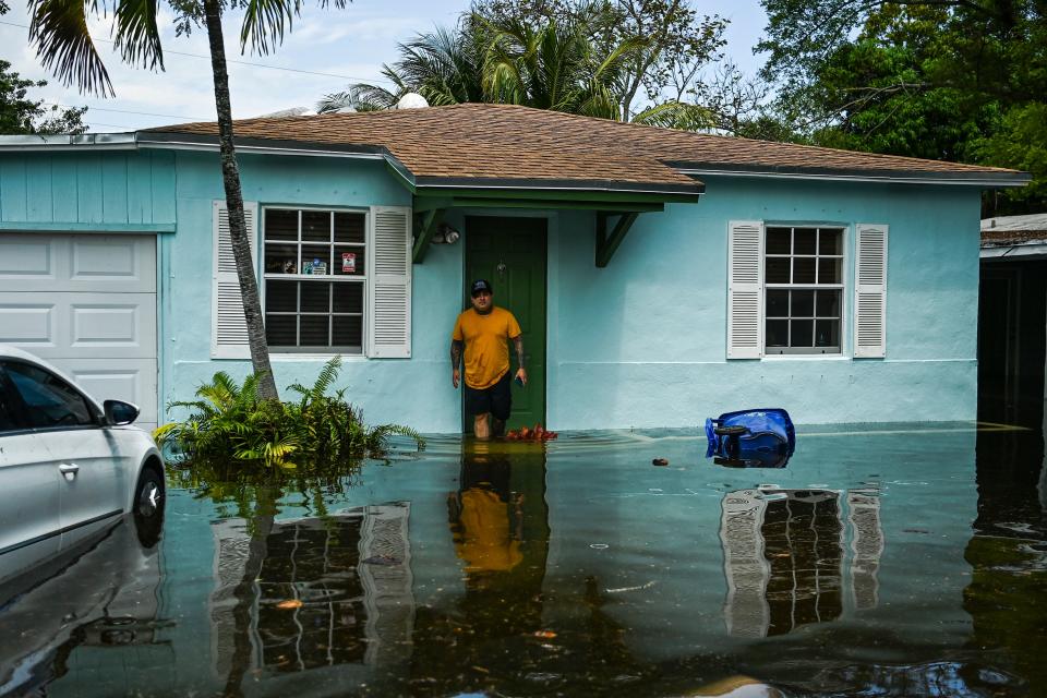 A man looks on as he stands outside of his flooded home after heavy rain in Fort Lauderdale, Florida on April 13, 2023. - Torrential rain has drenched much of greater Miami, leaving cars stranded and forcing the closure of schools and Fort Lauderdale's airport until at least Friday. (Photo by CHANDAN KHANNA / AFP) (Photo by CHANDAN KHANNA/AFP via Getty Images)