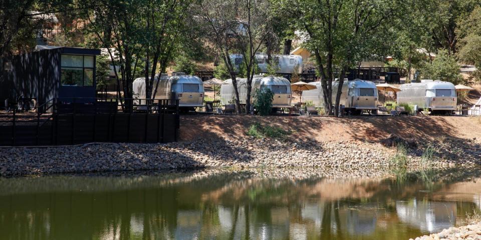 Autocamp Yosemite's lake with Airstreams and a cabin in the back