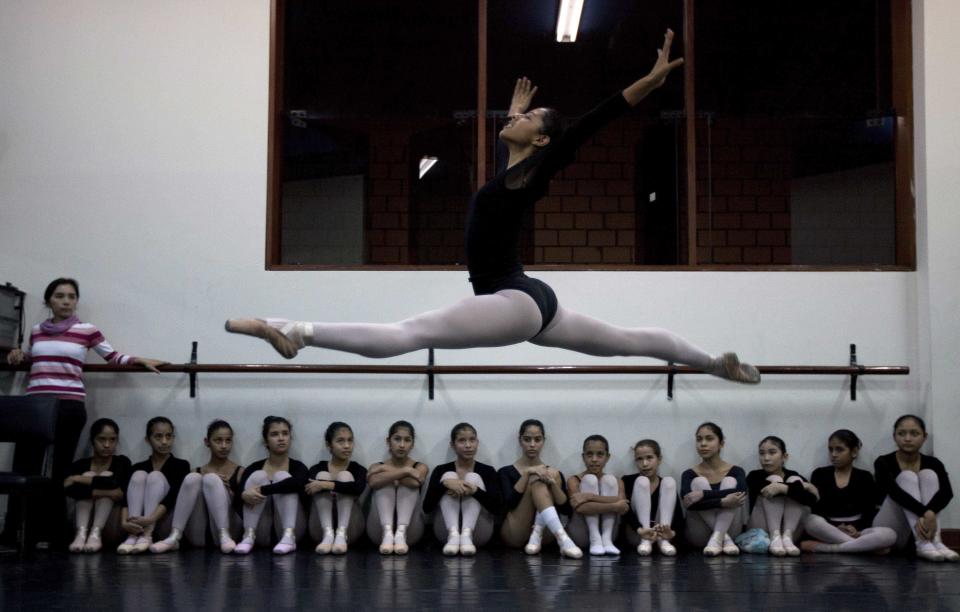 In this Aug. 28, 2012 photo, a dancer flies through the air as others watch as they practice for a competition between ballet schools at the National Superior Ballet School in Lima, Peru. Nearly 100 girls and boys from Colombia, Venezuela, Chile, France and Peru are submitting themselves to a week-long competition hoping to win medals from Peru's national ballet school _ and perhaps a grant to study in Miami. (AP Photo/Martin Mejia)