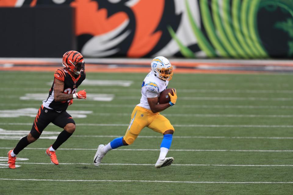 Chargers running back Josh Kelley is chased by Cincinnati Bengals' Jessie Bates.