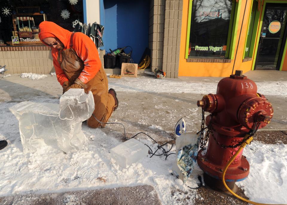 Dave Burrows creates an ice sculpture of a dog next to a fire hydrant during Ice Breaker 2015 in South Haven.