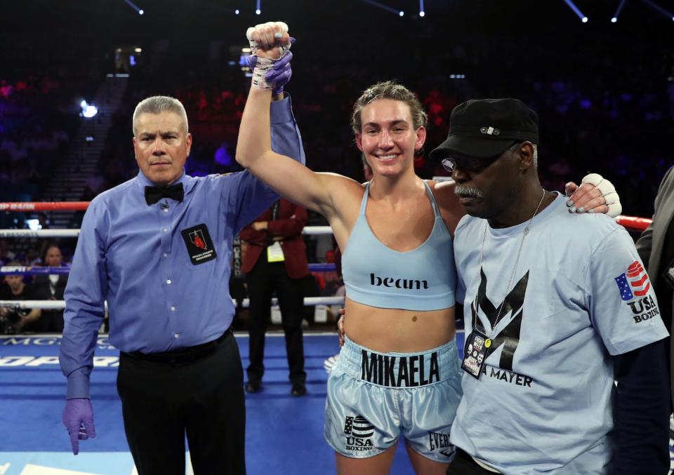 LAS VEGAS, NEVADA - JUNE 15:  Super featherweight boxer Mikaela Mayer (C) poses with referee Russell Mora and her trainer Al Mitchell after her unanimous-decision victory over Lizbeth Crespo at MGM Grand Garden Arena on June 15, 2019 in Las Vegas, Nevada.  (Photo by Steve Marcus/Getty Images)