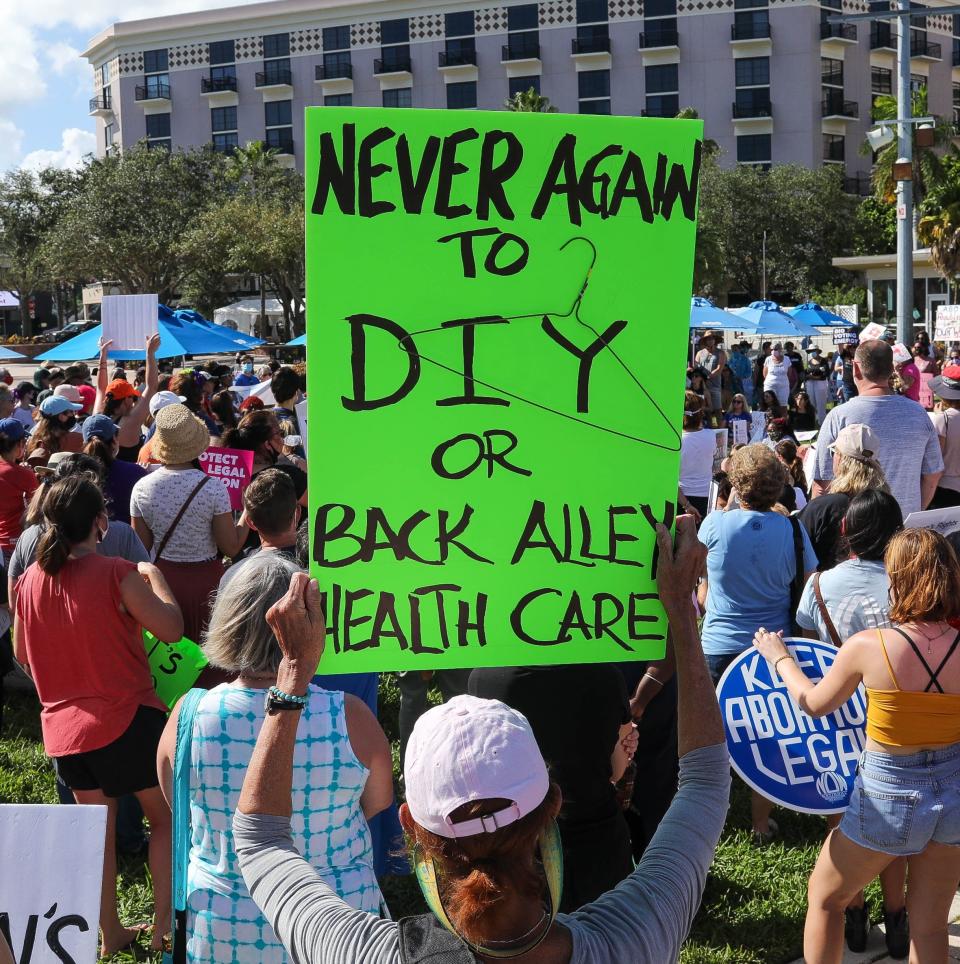 A woman holds up a sign during a Bans Off Our Bodies abortion rights protest at Clematis Street and Flagler Drive in West Palm Beach, Saturday, October 2, 2021.  