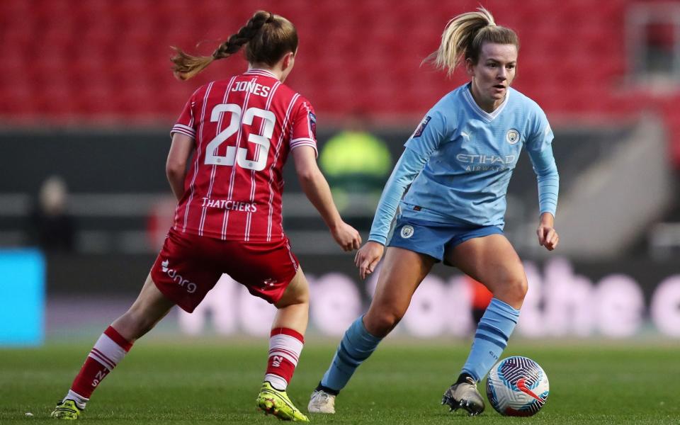 Lauren Hemp of Manchester City runs with the ball whilst under pressure from Carrie Jones of Bristol City