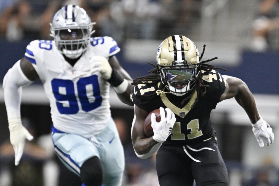 New Orleans Saints running back Alvin Kamara (41) breaks away with Dallas Cowboys defensive end DeMarcus Lawrence (90) in tow while running for a long touchdown during the first half of an NFL football game, Sunday, Sept. 15, 2024, in Arlington, Texas. (AP Photo/Tony Gutierrez)