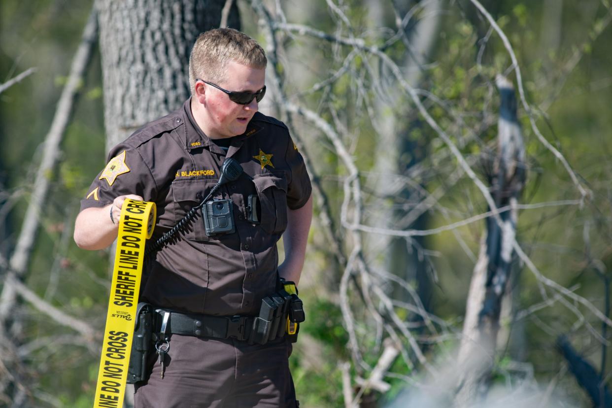 Vanderburgh County Sheriff’s Deputy Hunter Blackford attaches police tape around the 7300 Block of St. Joseph Road in German Township, Ind., where a shootout occurred earlier on Wednesday afternoon, April 12, 2023, between police and a man whose warrant was out for his arrest for violating his parole.