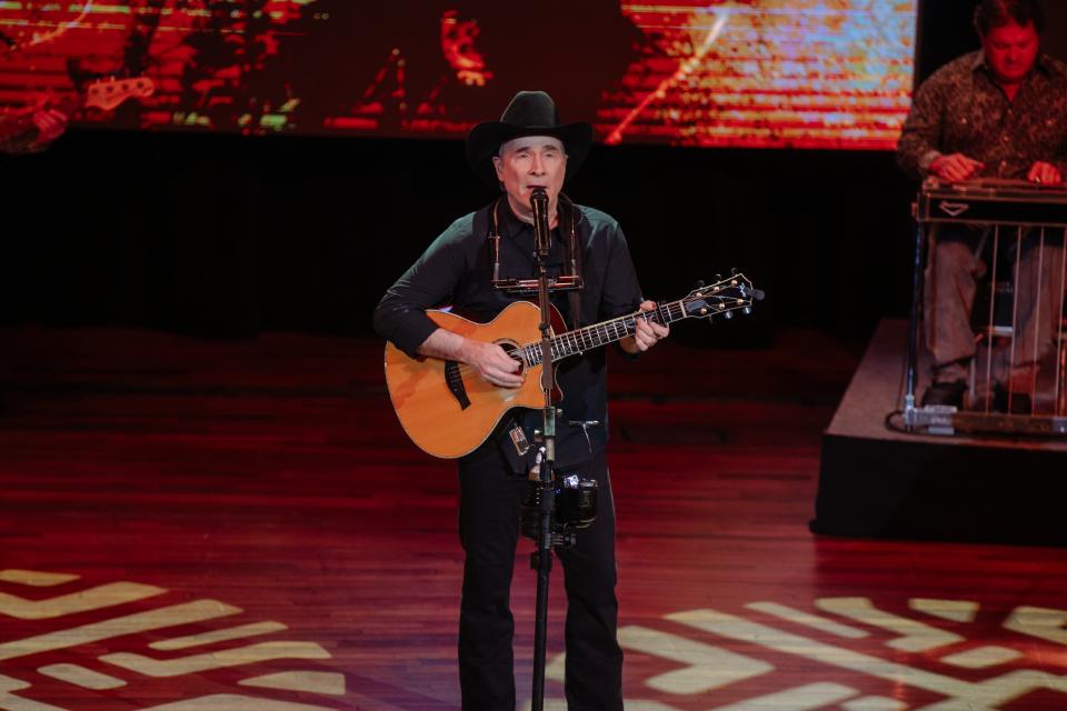 Clint Black singing and playing guitar on the Ryman stage