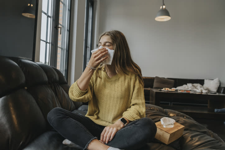 A woman blowing her nose