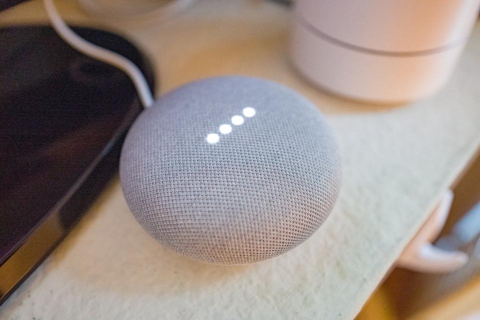 Close-up of Google Home Mini smart speaker with lights illuminated in a smart home in San Ramon, California, with Google Wifi mesh network router in background, March 26, 2019. (Photo by Smith Collection/Gado/Getty Images)