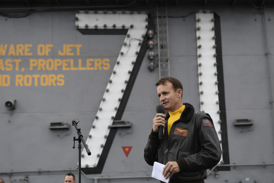 FILE - In this Nov. 15, 2019, file photo U.S. Navy Capt. Brett Crozier, then commanding officer of the aircraft carrier USS Theodore Roosevelt (CVN 71), addresses the crew during an all-hands call on the ship's flight deck while conducting routine operations in the Eastern Pacific Ocean. Crozier, the dismissed captain of the U.S. Navy aircraft carrier, knew he was jeopardizing his military career when he broke protocol and sent a now-famous email warning of possible sailor deaths due to a coronavirus breakout on board, but he did so in an urgent effort to help avoid a "larger catastrophe," he wrote in a witness statement obtained by the San Francisco Chronicle. (Mass Communication Specialist 3rd Class Nicholas Huynh/U.S Navy via AP, File)