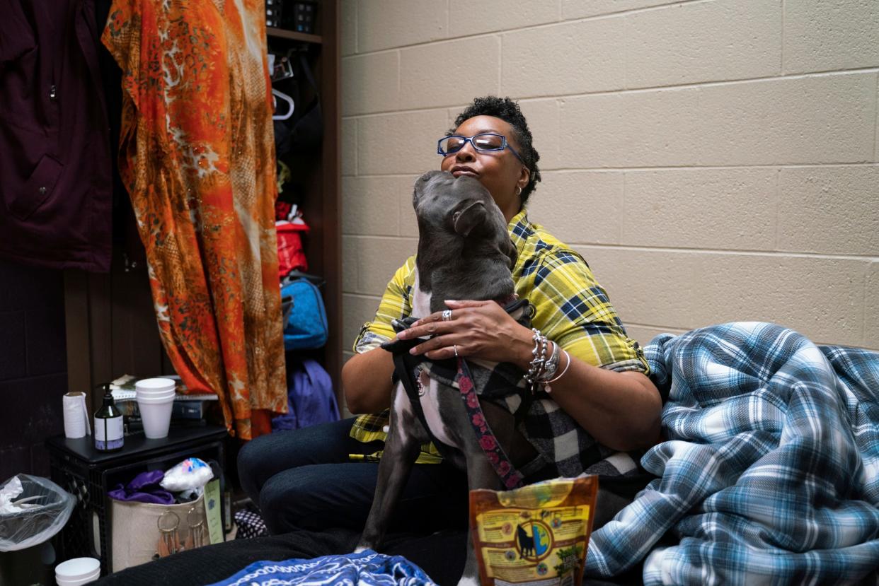 Tonya Hogan, 50, sits for a photo with her dog named Pepper inside their room at Harbor Light Salvation Army in Detroit on Thursday, March 9, 2023. Pepper, who socializes and lifts the spirits of other shelter residents, is known by some as the Salvation Army mascot.