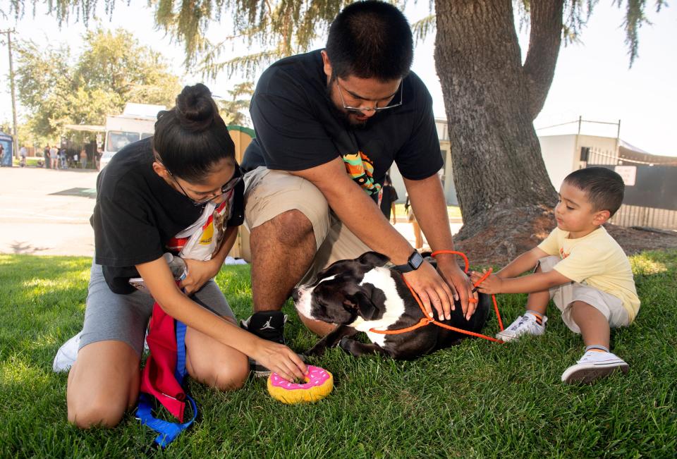 Sabrina and Ryan Gonzalez and their 2-year-old son Jayden pet "Nemo" whom they adopted from Stockton Animal Shelter in Stockton, California, on Aug. 20, 2022. More than 80 dogs and cats were available for free adoption to help relieve overcrowding at the shelter.