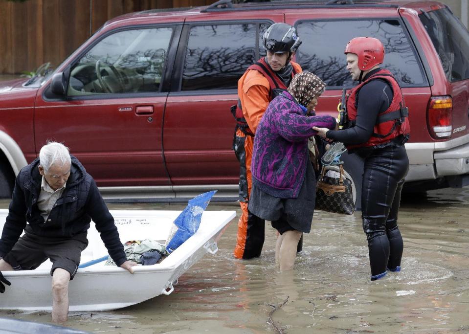 Rescue crews take out residents from a flooded neighborhood Tuesday, Feb. 21, 2017, in San Jose, Calif. Rescuers chest-deep in water steered boats carrying dozens of people, some with babies and pets, from a San Jose neighborhood inundated by water from an overflowing creek Tuesday. (AP Photo/Marcio Jose Sanchez)