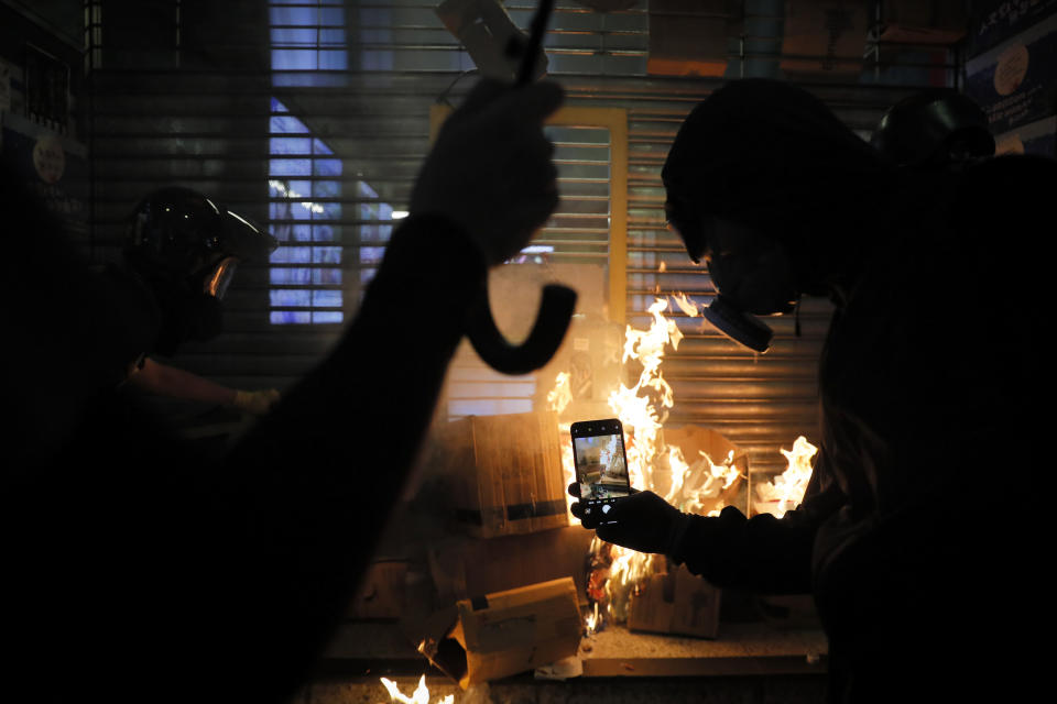 A fire set by protesters burns an entrance to the Wan Chai MTR subway station in Hong Kong, Sunday, Sept. 15, 2019. Police fired a water cannon and tear gas at protesters who lobbed Molotov cocktails outside the Hong Kong government office complex Sunday, as violence flared anew after thousands of pro-democracy supporters marched through downtown in defiance of a police ban. (AP Photo/Kin Cheung)